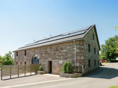 un antiguo edificio de ladrillo con techo solar en Heritage Holiday Home in Ovifat with Sauna, en Waimes