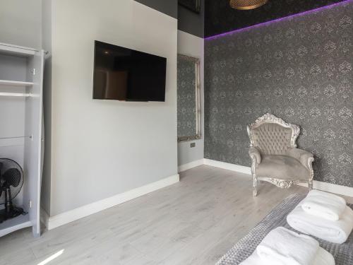 a living room with a chair and a tv at Coastal Gem - Uk2773 in Llandudno