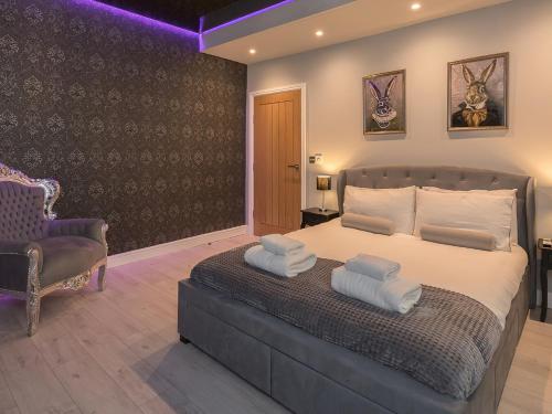 a bedroom with a large bed and a chair at Coastal Gem - Uk2773 in Llandudno