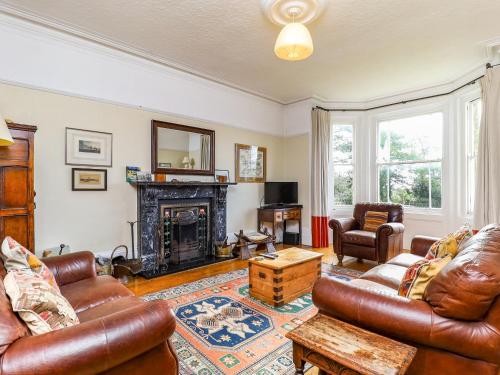 a living room with leather furniture and a fireplace at Downedge in Brading