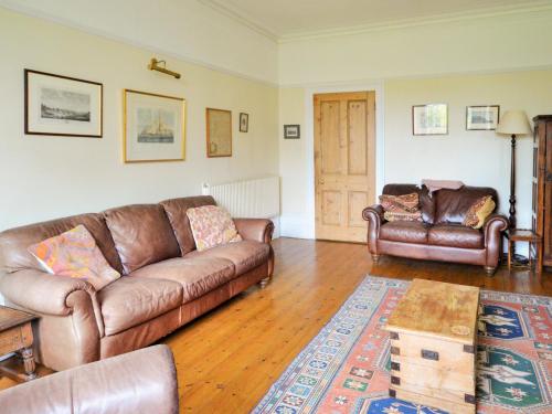 a living room with two leather couches and a rug at Downedge in Brading