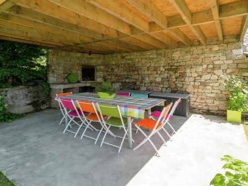 eine Terrasse mit einem Tisch und Stühlen unter einer Steinmauer in der Unterkunft Heritage Holiday Home in Ovifat with Sauna in Weismes