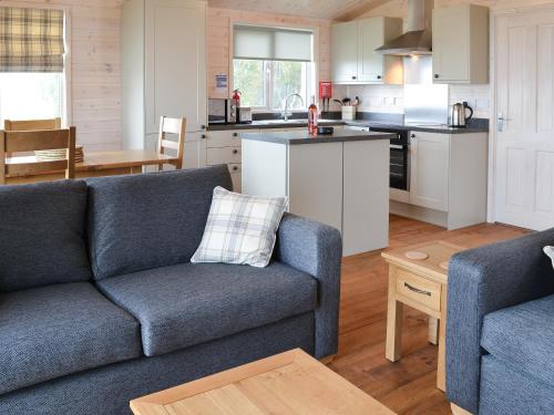 a living room with a couch and a kitchen at Ben Klibreck in Kinloss
