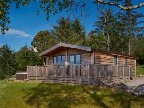 a cabin in the woods with a wooden fence at Ben Klibreck in Kinloss