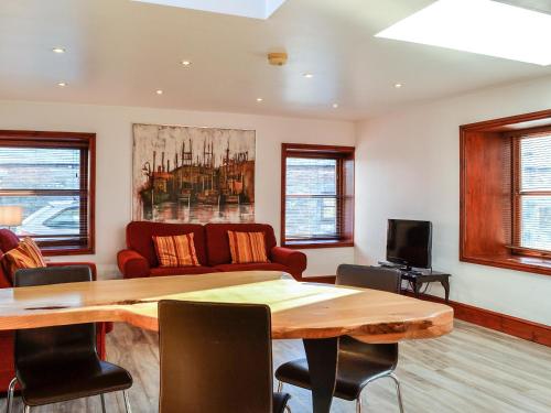 a living room with a table and a couch at Anne's Cottage - Uk7782 in Newton Stewart