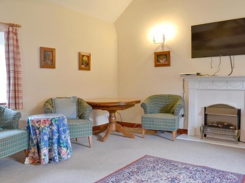a living room with chairs and a table and a fireplace at The Walton - Ukc3232 in Onibury