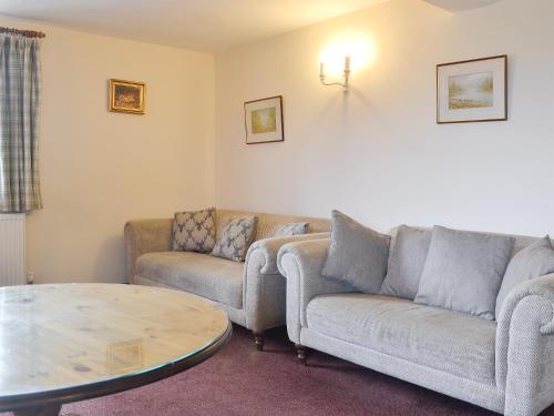 a living room with two couches and a table at The Walton - Ukc3232 in Onibury