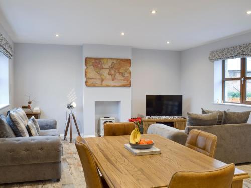 a living room with a wooden table and a couch at The Corn Store in Malpas