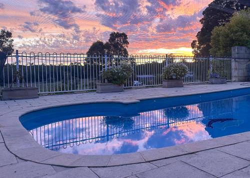 a swimming pool with a sunset in the background at Gum Tree Hideaway by Tiny Away in Stoneville