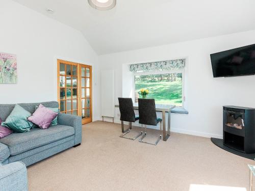 a living room with a couch and a table at The Byre in Kirkcudbright