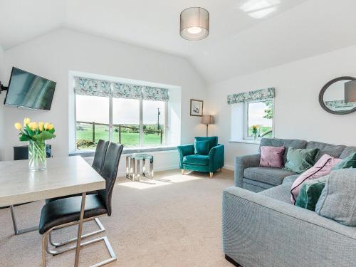 a living room with a couch and a table at The Byre in Kirkcudbright