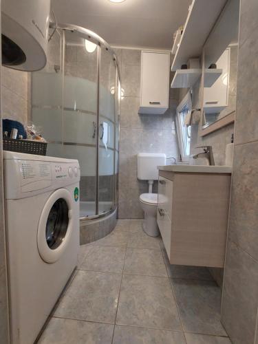 a small bathroom with a washing machine in it at Ester in Kastav
