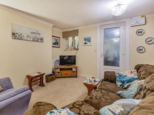 a living room with a couch and a tv at The Garden Flat in Torquay