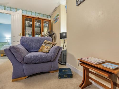 a living room with a purple chair and a table at The Garden Flat in Torquay