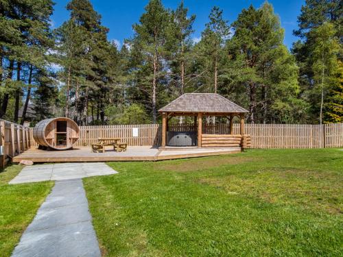 a gazebo in a backyard with a fence at Delmhor No4 in Aviemore