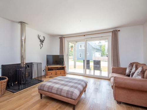 a living room with a couch and a tv at Delmhor No4 in Aviemore