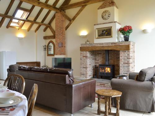 a living room with leather furniture and a fireplace at The Hayloft-W42941 in Burn