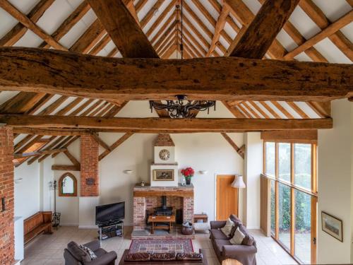 a living room with wooden ceilings and a fireplace at The Hayloft-W42941 in Burn
