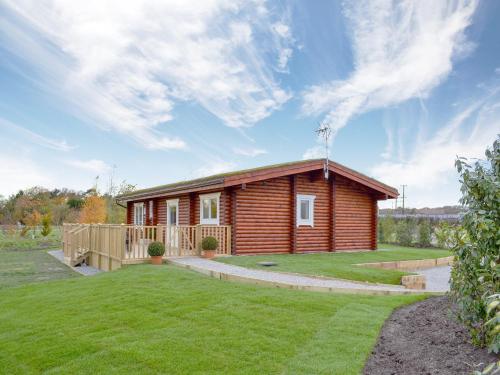 a small wooden cabin with a grass yard at Teal Lodge- Ukc2565 in Burn