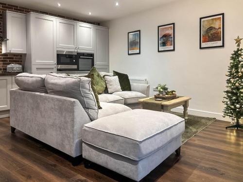a living room with two couches and a christmas tree at Coachmans Cottage in Settle