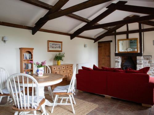 a living room with a red couch and a table at Honeysuckle Cottage - Ukc4692 in Kilkhampton
