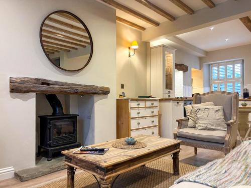 a living room with a table and a mirror at Bailey Cottage in Skipton