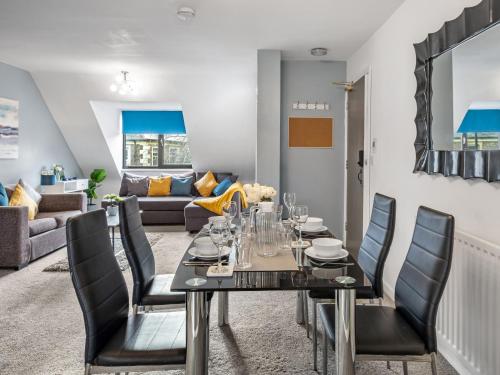 a dining room with a table and chairs and a living room at Sandyford Apartment in Jesmond