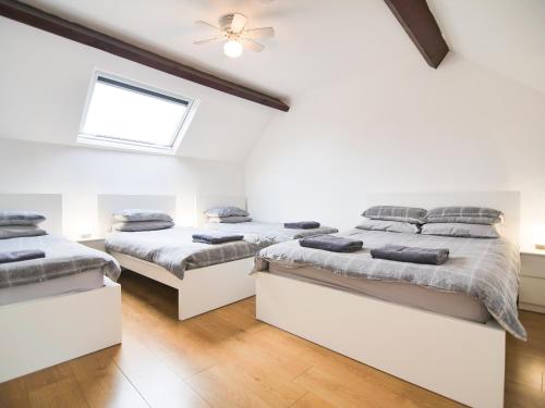 two beds in a room with white walls and wooden floors at Cottage 2 - Ukc3179 in York