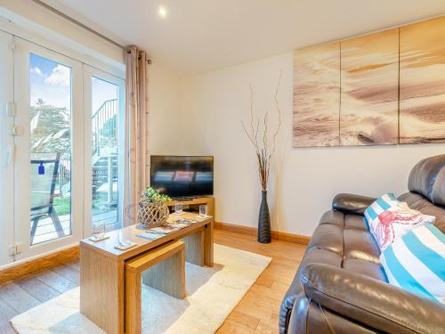 a living room with a couch and a tv at 20 Mount Brioni in Downderry