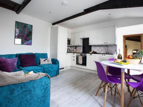 a living room with a blue couch and a table at Lavender Cottage - Ukc4695 in Kilkhampton