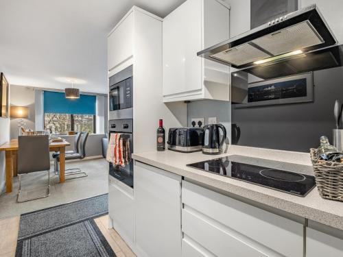 a kitchen with white cabinets and a counter top at Ouseburn Apartment in Jesmond