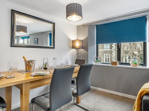 a dining room with a table and chairs and a window at Ouseburn Apartment in Jesmond