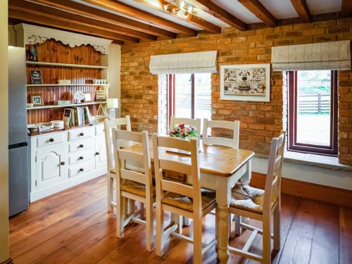 a dining room with a wooden table and chairs at The Threshing Barn - Ukc8847 in Timberland