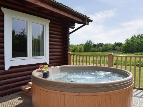 a hot tub on a deck next to a house at Quail Lodge - W44304 in Burn