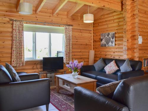 a living room with leather couches and a television at Quail Lodge - W44304 in Burn