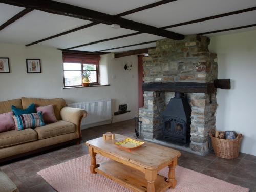 a living room with a stone fireplace and a couch at Rose Cottage - Ukc4693 in Kilkhampton