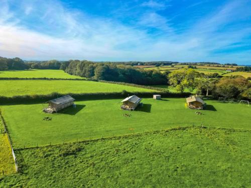 an aerial view of a large green field with tents at Cuckoo - Safari Tent - Ukc8981 in Romsey
