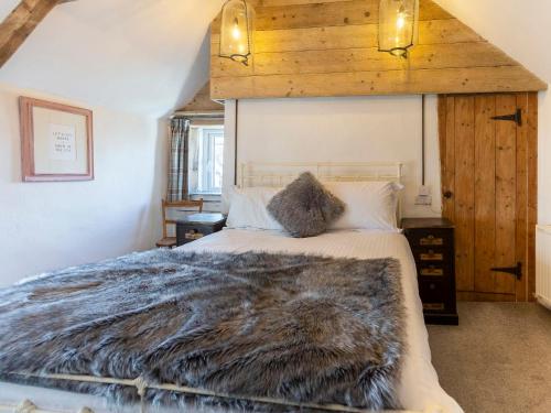 a bedroom with a bed with a furry blanket on it at Fuchia in Marhamchurch
