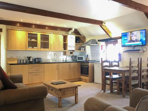 a kitchen and living room with a couch and a table at Porth Cottage- W40885 in Perranporth