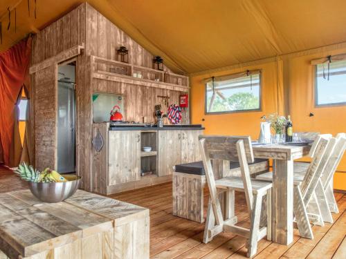 a kitchen with wooden cabinets and a table and chairs at Swallow - Safari Tent - Ukc8985 in Romsey