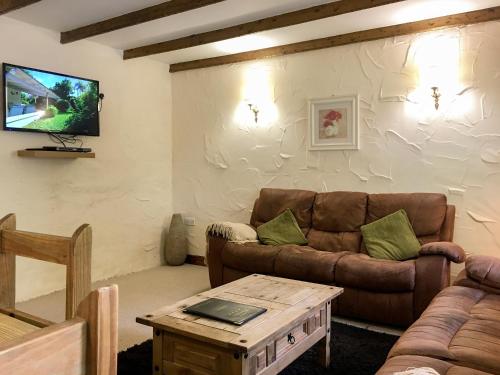 a living room with a couch and a tv at Crantock Cottage- W40888 in Perranporth