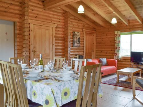 a dining room with a table in a log cabin at Mallard Lodge - W43171 in Burn