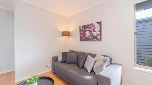 a living room with a couch and a window at Nouveau Home in Epsom