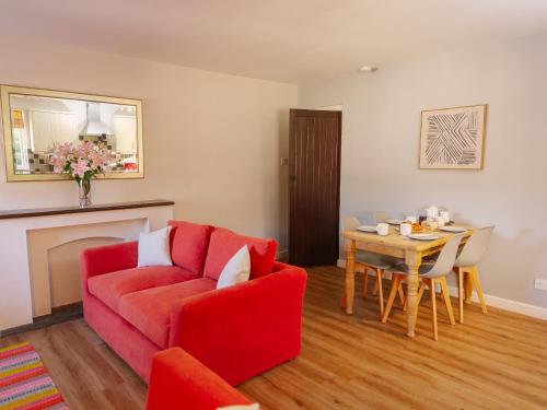 a living room with a red couch and a table at Number Four - Ukc4966 in Tawstock