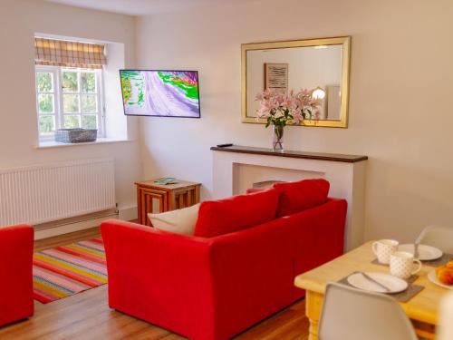 a living room with a red couch and a fireplace at Number Four - Ukc4966 in Tawstock