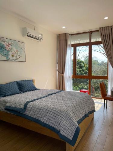 a bedroom with a bed and a large window at BM homestay in Buôn Dhă Prŏng