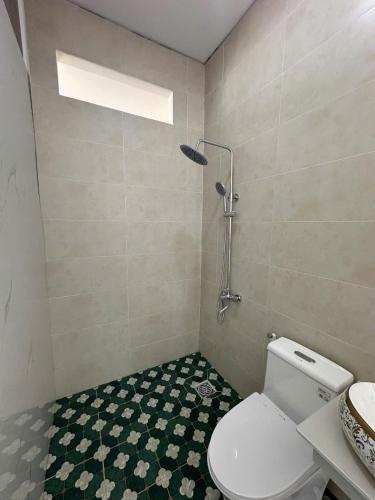 a bathroom with a toilet and a shower in it at BM homestay in Buôn Dhă Prŏng