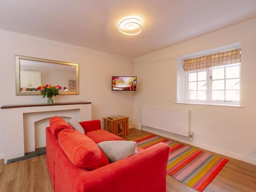 a living room with a red couch and a fireplace at Number Five - Ukc4967 in Tawstock