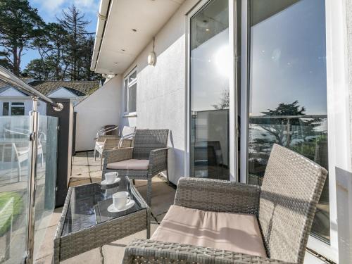 a patio with chairs and a glass table on a balcony at 10 Mount Brioni in Downderry