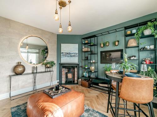 a living room with green walls and a mirror at 17 Mount Brioni in Downderry